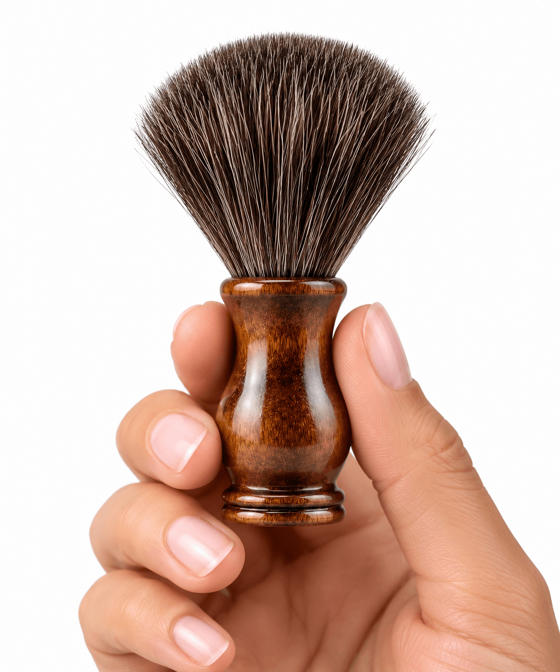 A hand holding the Omnia Bene Heritage shave brush with its dense knot and polished wood handle.