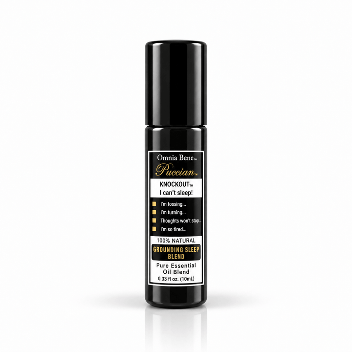 Omnia Bene Puccian KNOCKOUT grounding sleep blend, a 10 mL black essential oil rollerball. Roman chamomile, lavender, vetiver, sandalwood and ylang ylang in a pure essential oil roll-on. For the end of the day and a bedtime routine. Grounding and quiet - roll onto wrists and the base of the throat before bed.