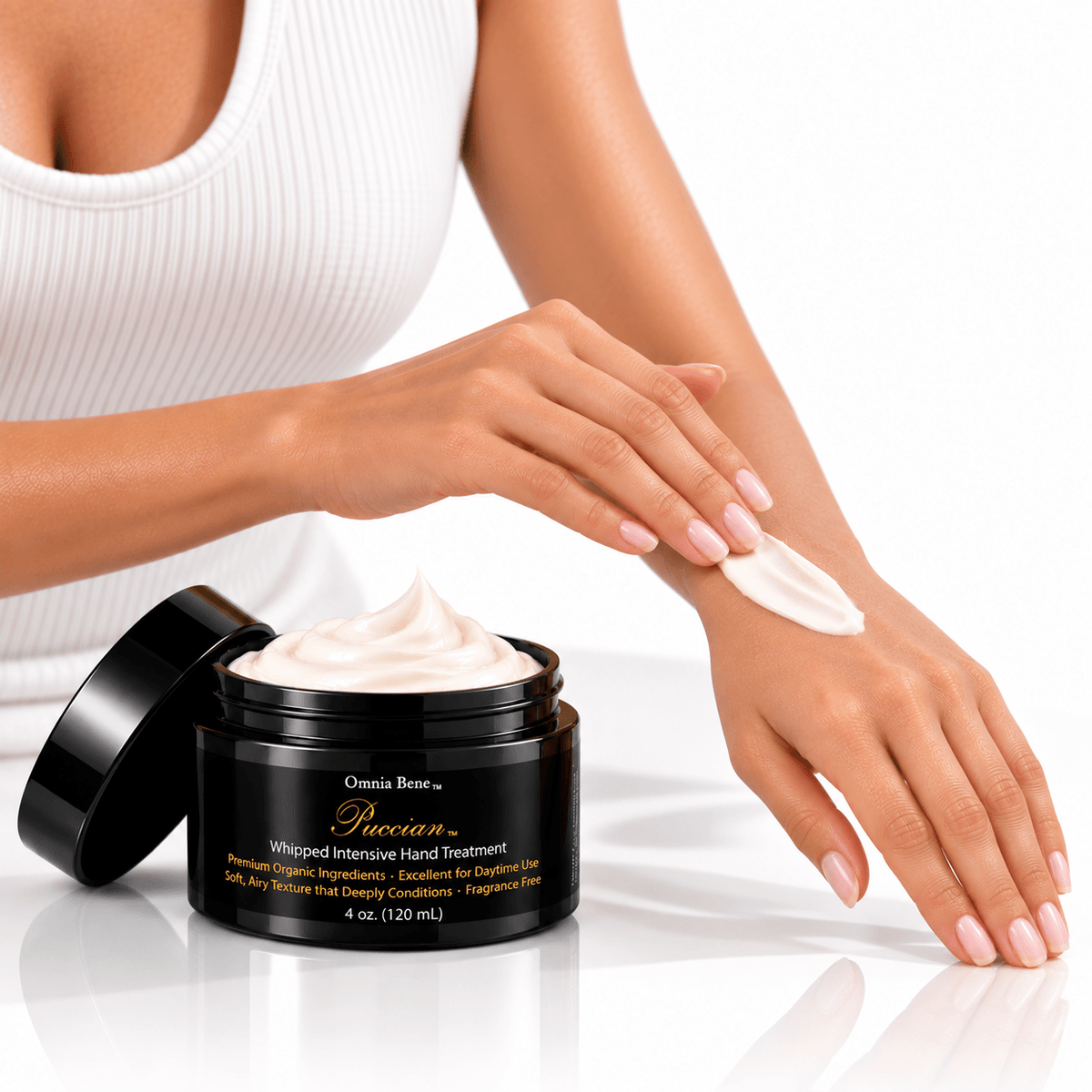 Omnia Bene Puccian Whipped Intensive Hand Treatment smoothed over the back of a hand, with the open jar alongside.