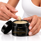 A fingertip lifting Omnia Bene Puccian Intensive Restorative Hand Treatment from its open jar.