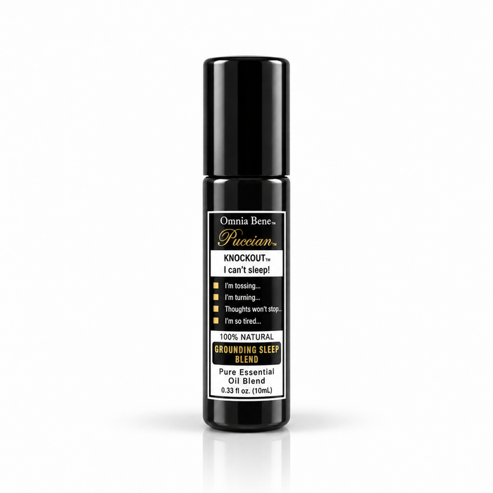 Omnia Bene Puccian KNOCKOUT grounding sleep blend, a 10 mL black essential oil rollerball. Roman chamomile, lavender, vetiver, sandalwood and ylang ylang in a pure essential oil roll-on. For the end of the day and a bedtime routine. Grounding and quiet - roll onto wrists and the base of the throat before bed.